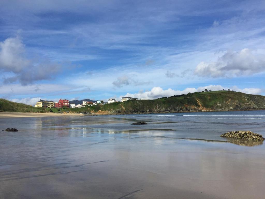 uitzicht op een strand met huizen op een heuvel bij Apartamento San Antón in Porto de Espasante