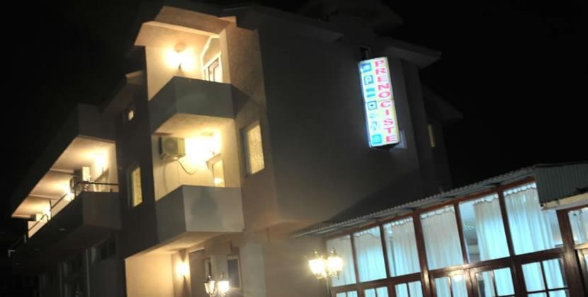 un edificio con un cartel en su costado por la noche en Prenoćište Trio en Vranje