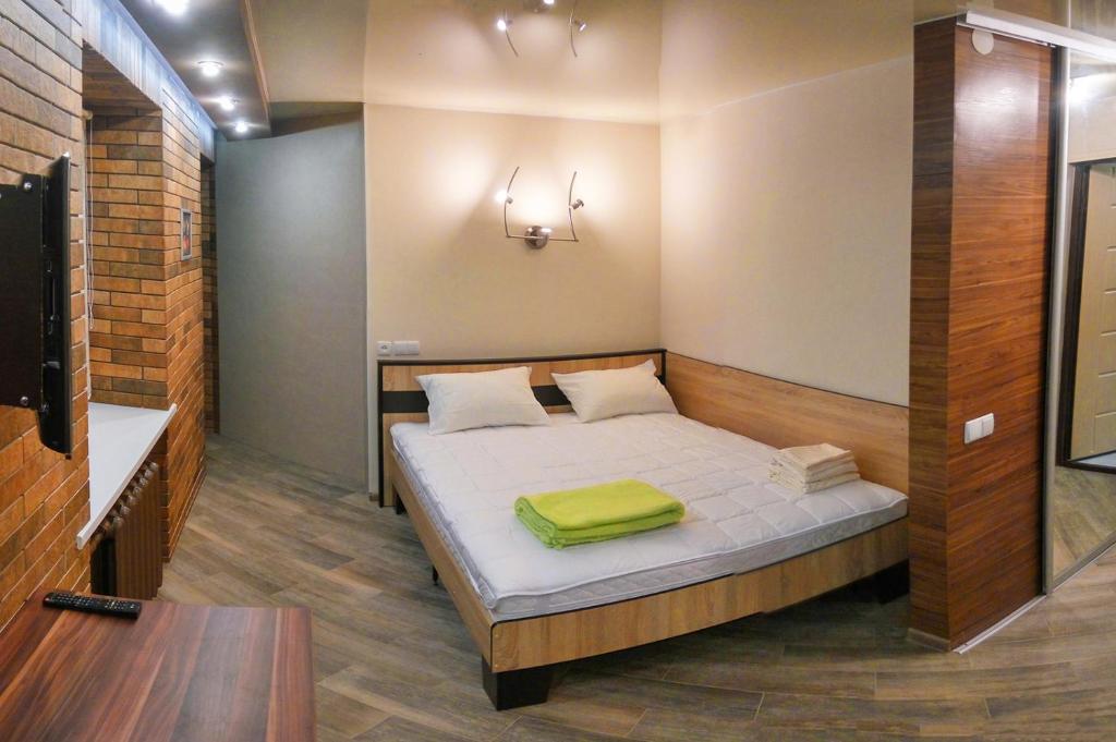 a bedroom with a bed with a green blanket on it at Luxury Loft в центре Полтавы in Poltava