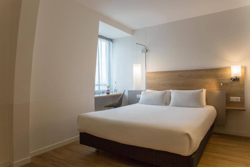 シュノーヴにあるThe Originals City, Hôtel Armony, Dijon Sud (Inter-Hotel)のベッドルーム(白いシーツを使用した大型ベッド1台付)