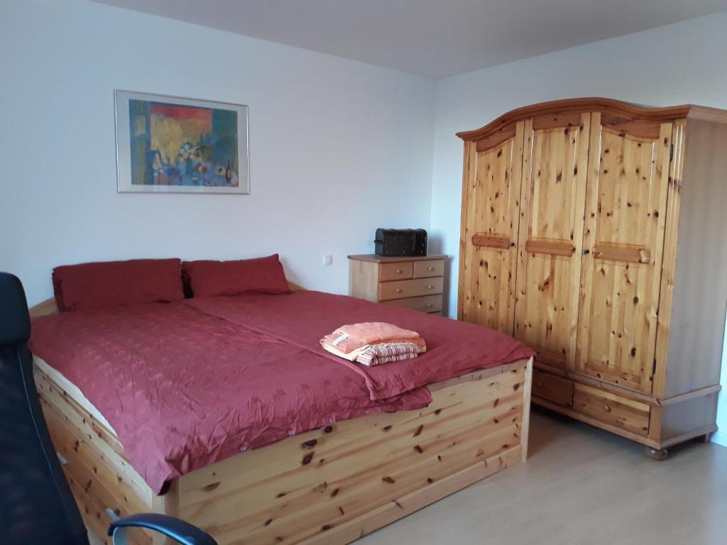 1 dormitorio con cama de madera y armario de madera en Liebigstraße 25, en Mülheim an der Ruhr