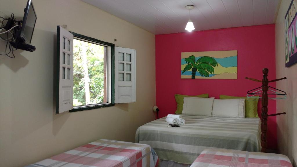 a bedroom with two beds and a window at Pousada Solar das Andorinhas in Fernando de Noronha
