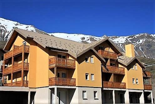 Villar-dʼArèneにあるAppartement à la Montagneの雪山を背景にした大きなアパートメントビル