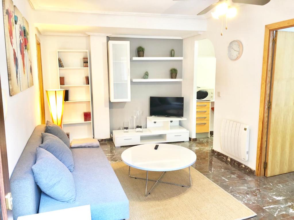 salon z niebieską kanapą i stołem w obiekcie Apartamento Conde II w Saragossie