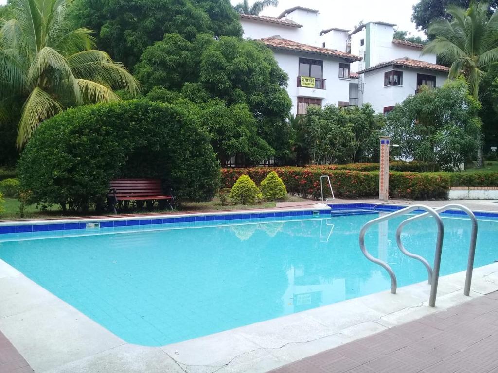 a swimming pool with a bench next to a building at Hostería tropical la florida in La Florida