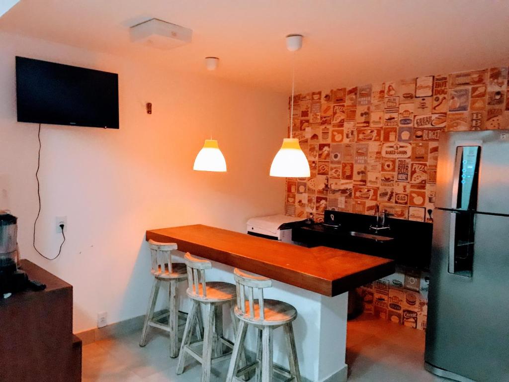 una cucina con bar con sgabelli e lavandino di Privilege Apart Centro Pipa, La Piazzetta by PipaCharme a Pipa