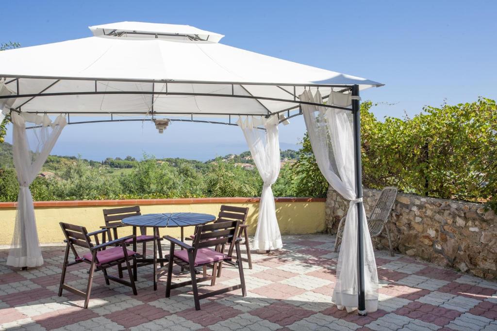 un tavolo e sedie sotto un ombrellone bianco su un patio di Villetta Gloria - Goelba a Portoferraio