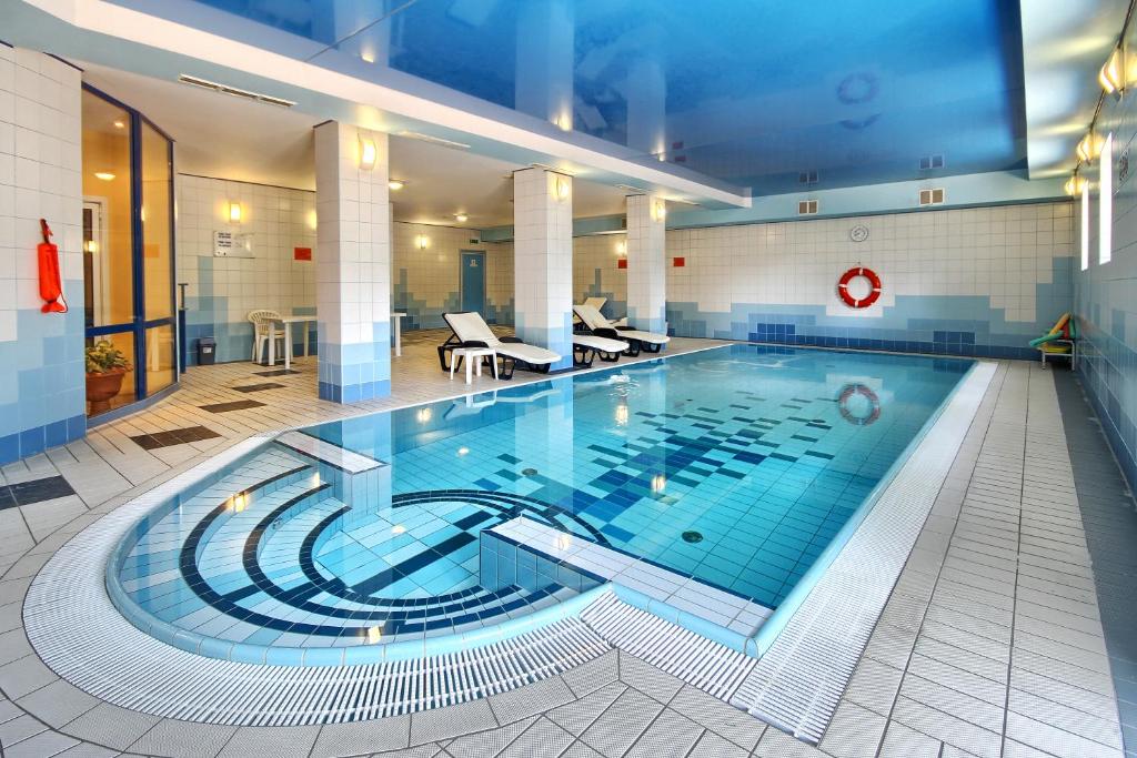 a large swimming pool in a hotel room at Hotel Festival in Opole