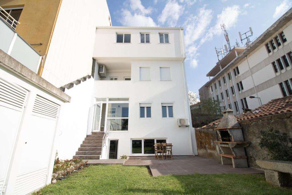 a white house with a yard in front of it at Casas do Paço - Philosophy Apartments in Braga