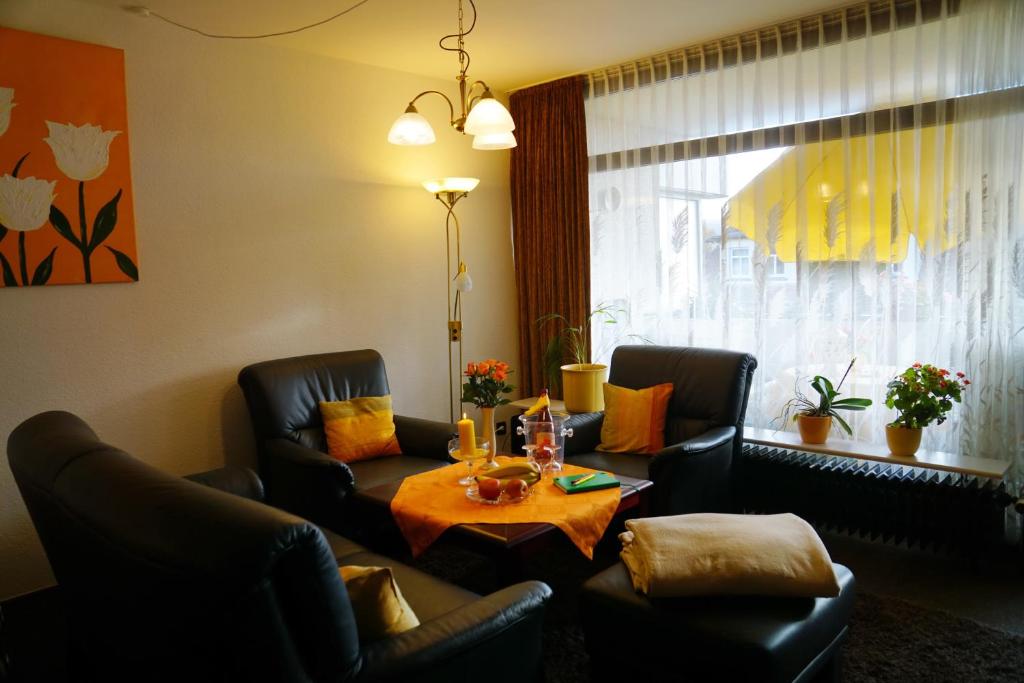 バート・ピルモントにあるFerienwohnung ALTENAUのリビングルーム(テーブル、椅子2脚付)