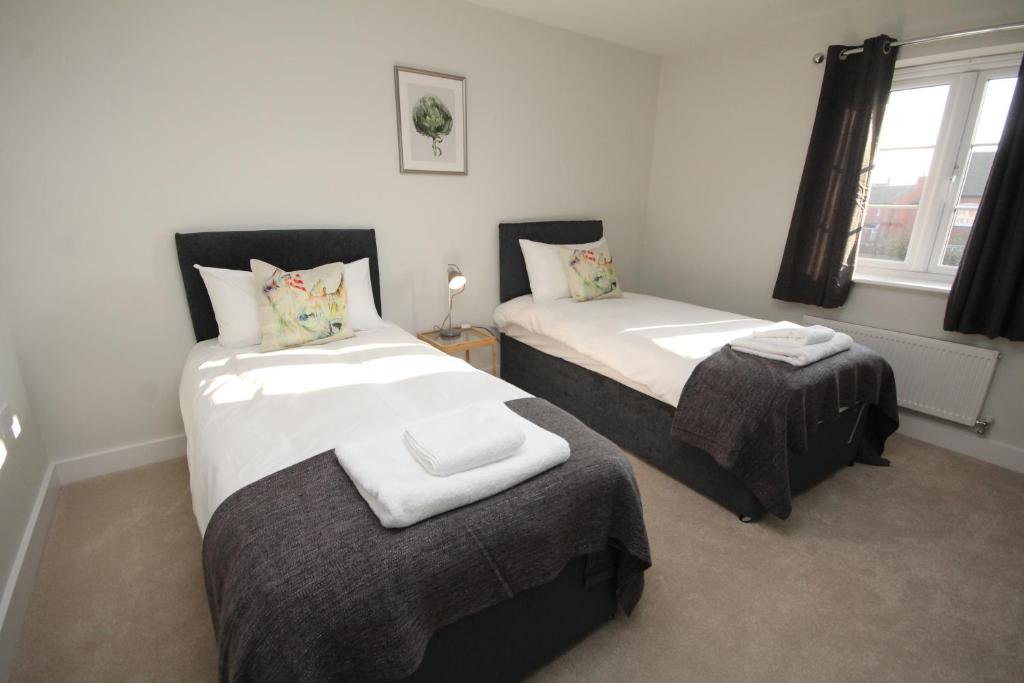 a bedroom with two beds and a table in it at The Hanwell in Banbury