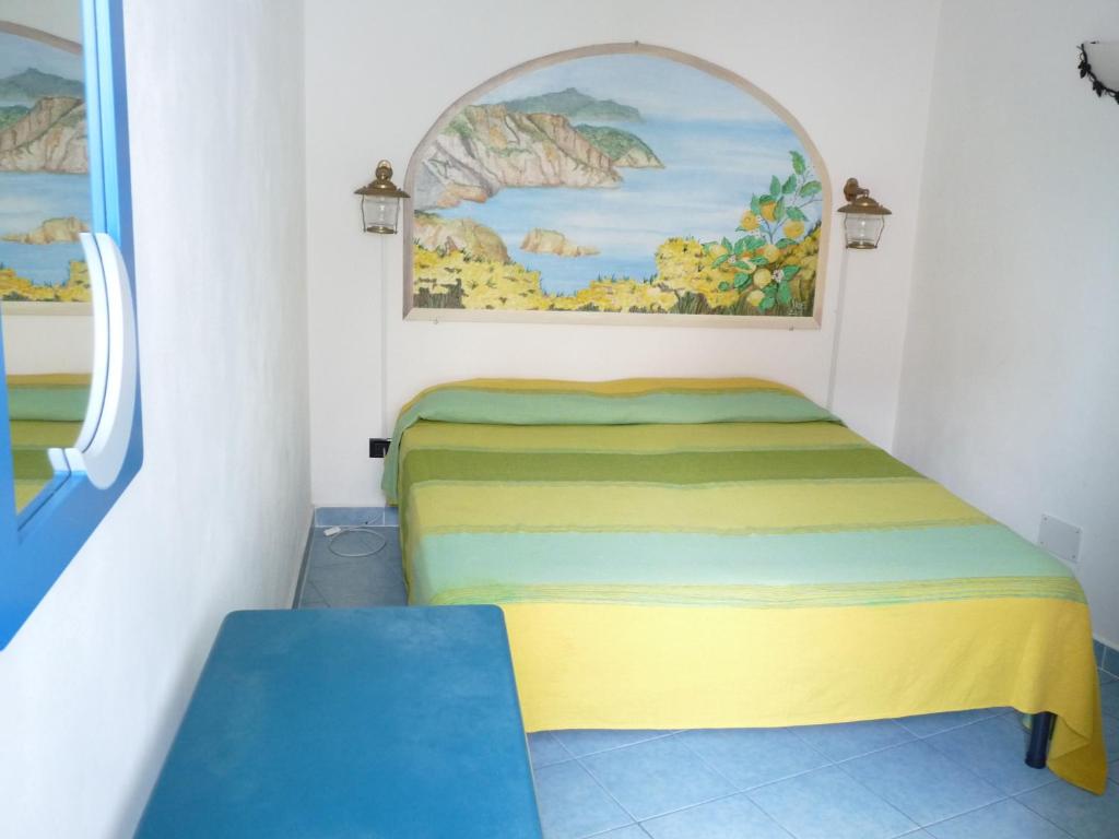 um pequeno quarto com uma cama e uma janela em Aprea Apartments em Ponza