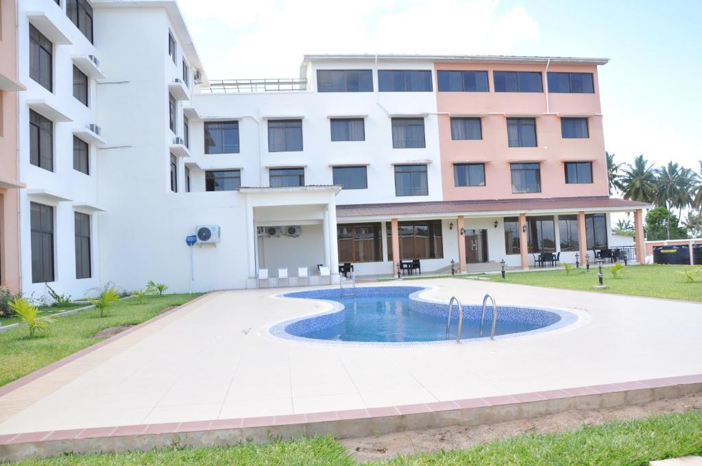 ein Gebäude mit einem Pool vor einem Gebäude in der Unterkunft Luwa Evergreen Hotel in Mtwara