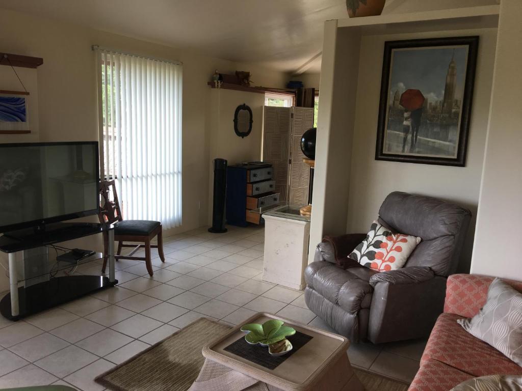 sala de estar con sofá y TV en Mediteranean style Ohana Rental / Loft & Sundeck panoramic OCEAN VIEW en Honolulu Landing