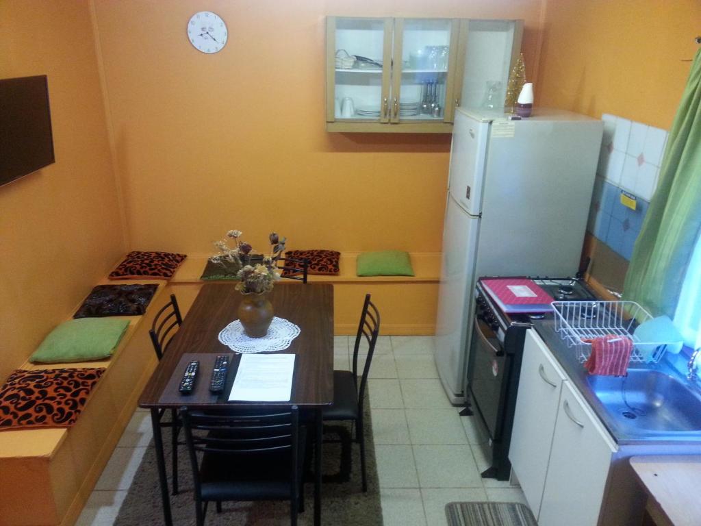 a small kitchen with a table and a refrigerator at Departamento a minutos del centro in Puerto Montt