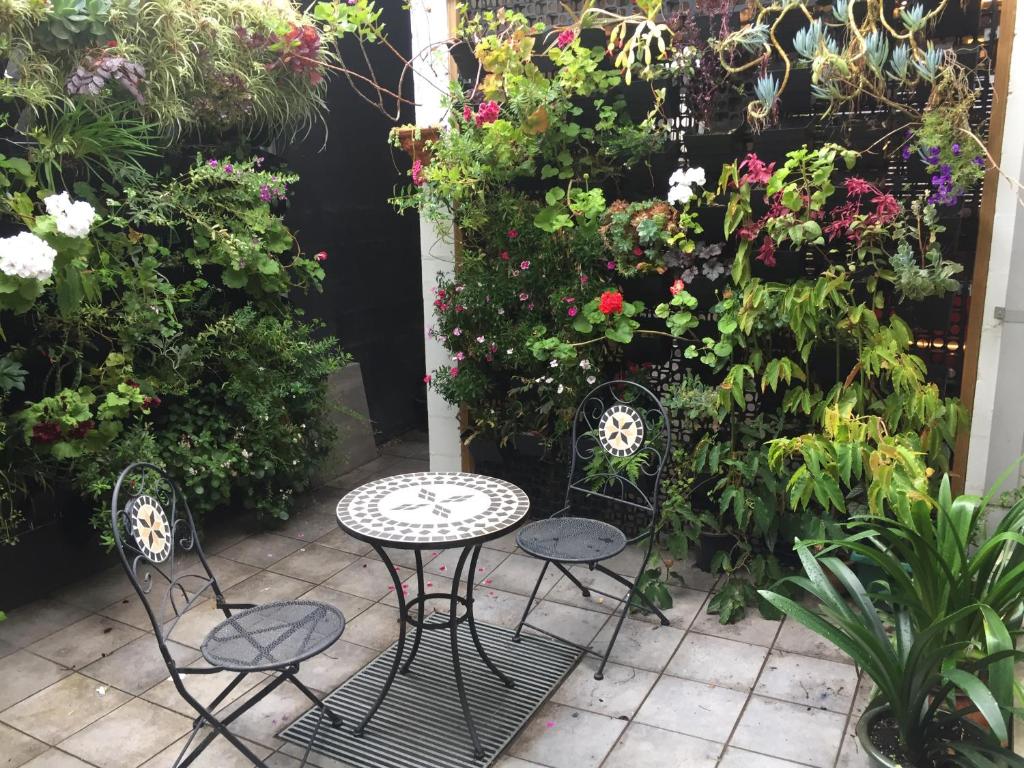 a patio with two chairs and a table and flowers at Brunswick B & B in Melbourne