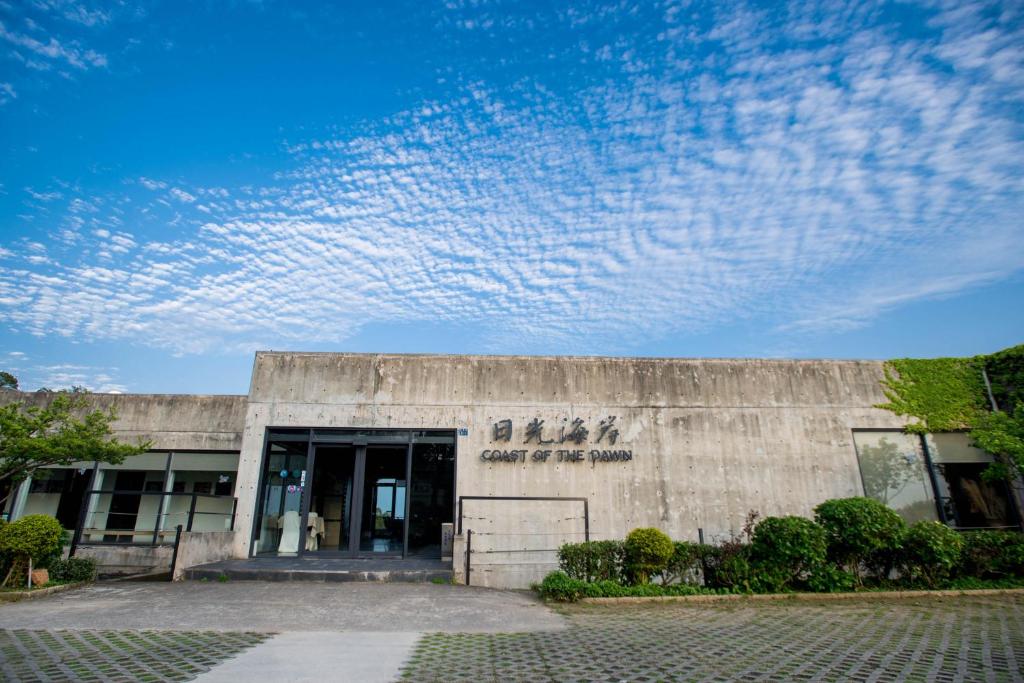 a concrete building with a blue sky with clouds at Dayspring Inn in Nangan