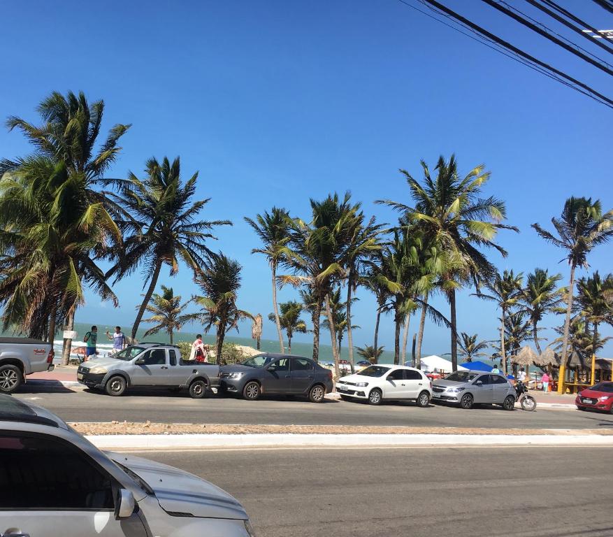 a group of cars parked in a parking lot with palm trees at Roma Garden in São Luís