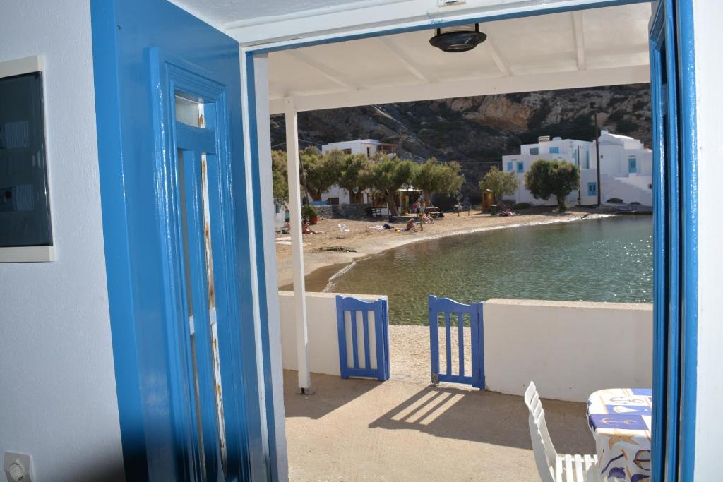 widok na plażę z domu z niebieskimi krzesłami w obiekcie Seafront Studio w mieście Cherronisos