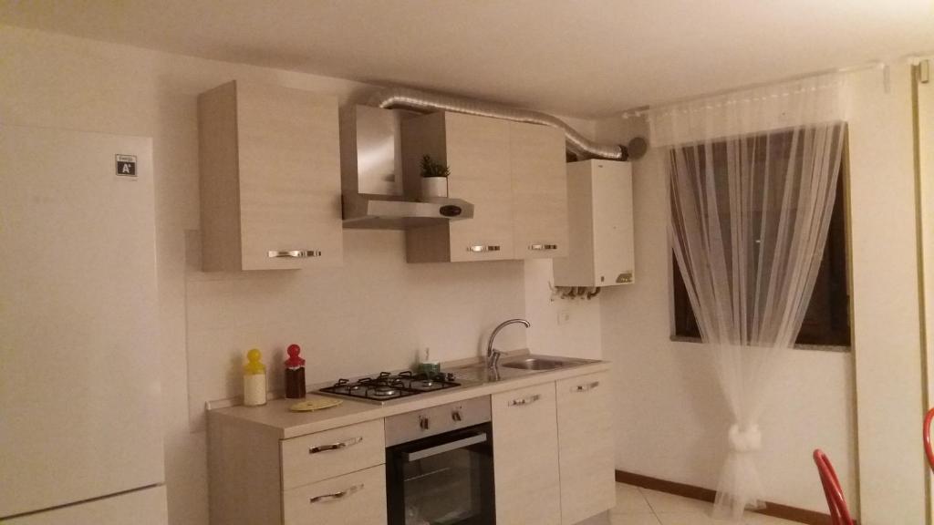cocina con armarios blancos y fogones en Appartamento Casa Elettra en Martinsicuro