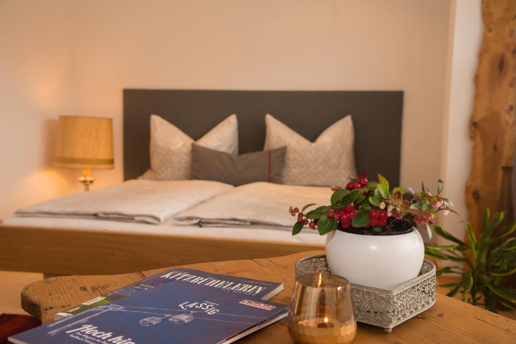 una camera da letto con un letto e un tavolo con un vaso fiorito di sunside Wiesersberg a Saalfelden am Steinernen Meer