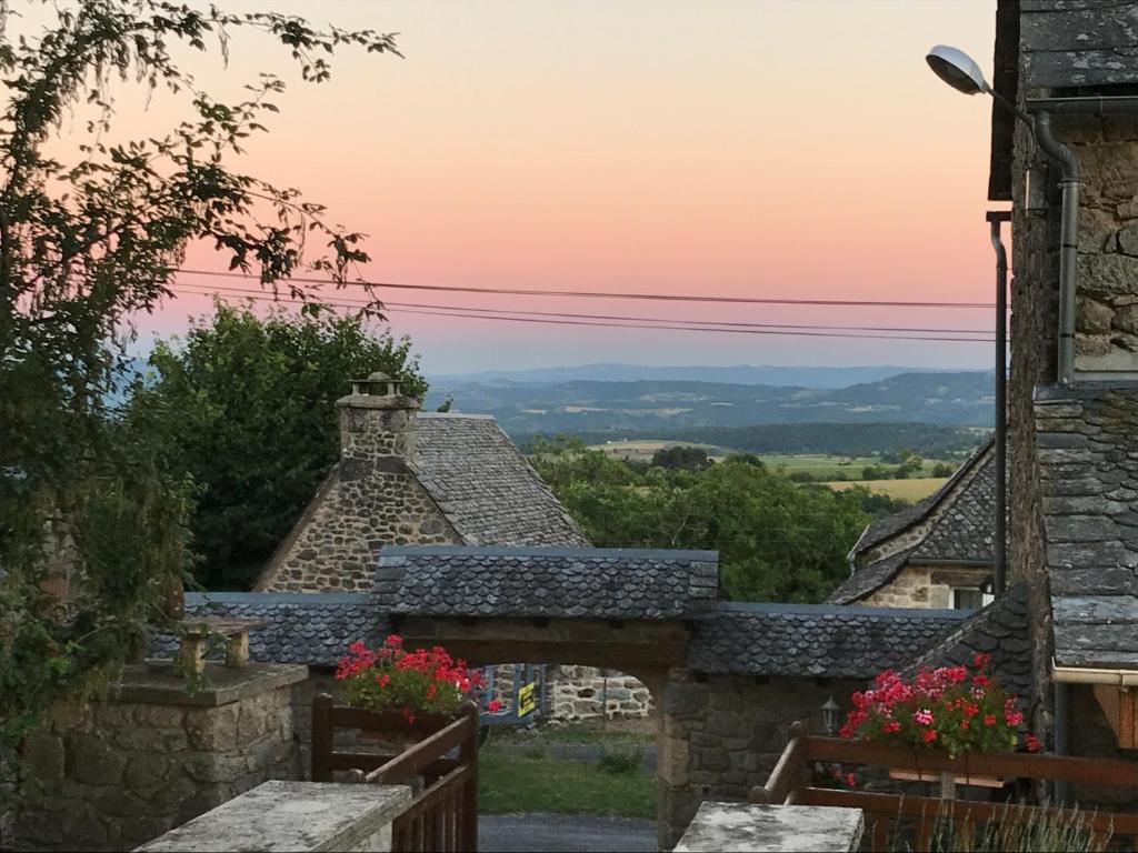 a view of a building with a sunset in the background at Lo Soulenquo à Fonteilles sur le GR 65 in Golinhac