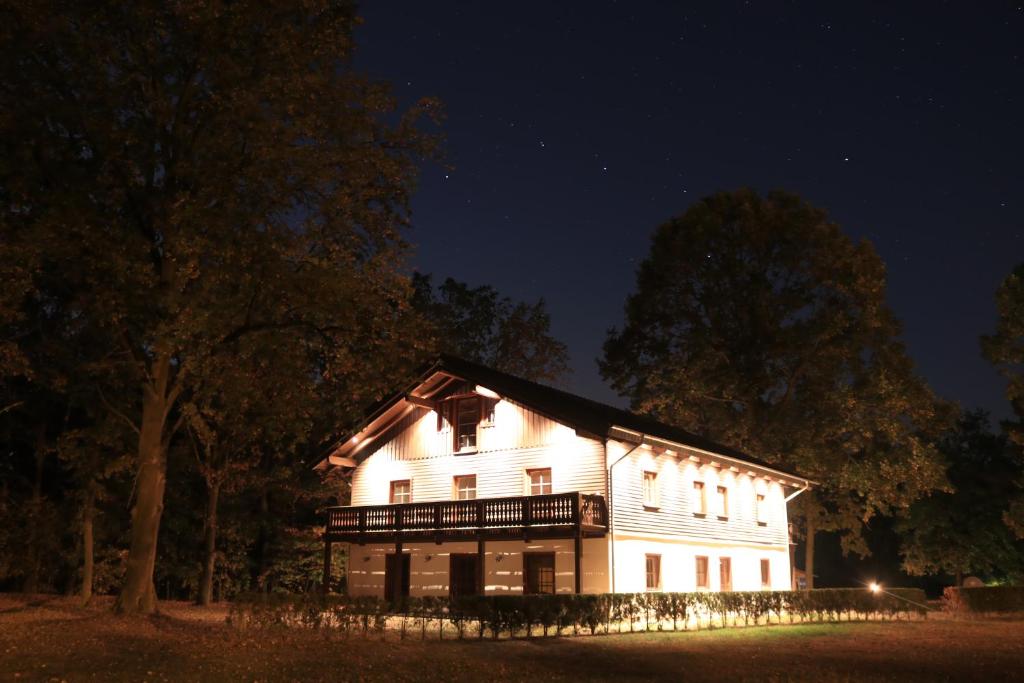 ein großes weißes Haus in der Nacht in der Unterkunft Störitzland Betriebsgesellschaft mbH in Grünheide