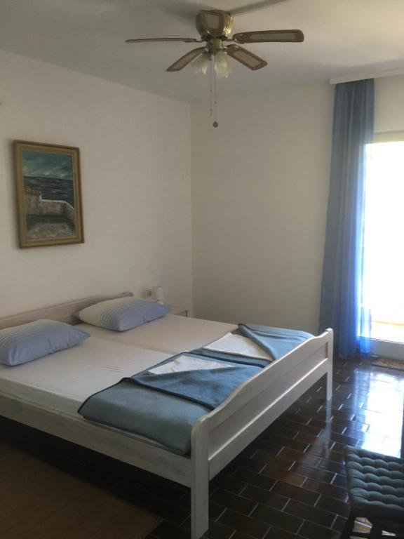 a bedroom with a bed with a ceiling fan at Seaview Antonija in Veli Lošinj