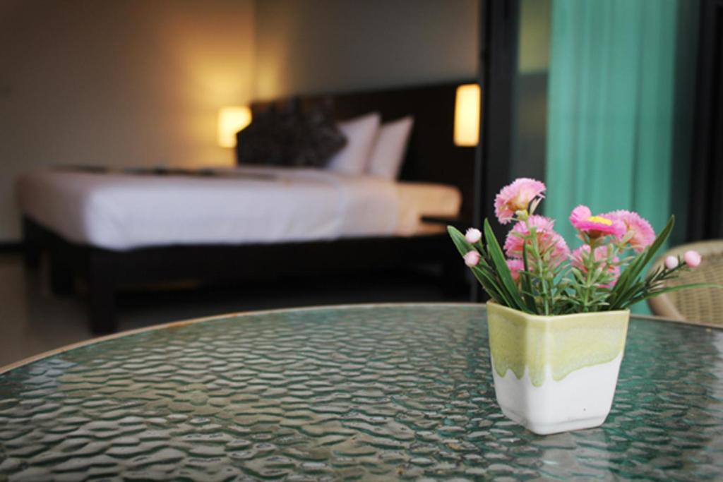 a vase of flowers sitting on a table in a hotel room at Simplitel in Karon Beach