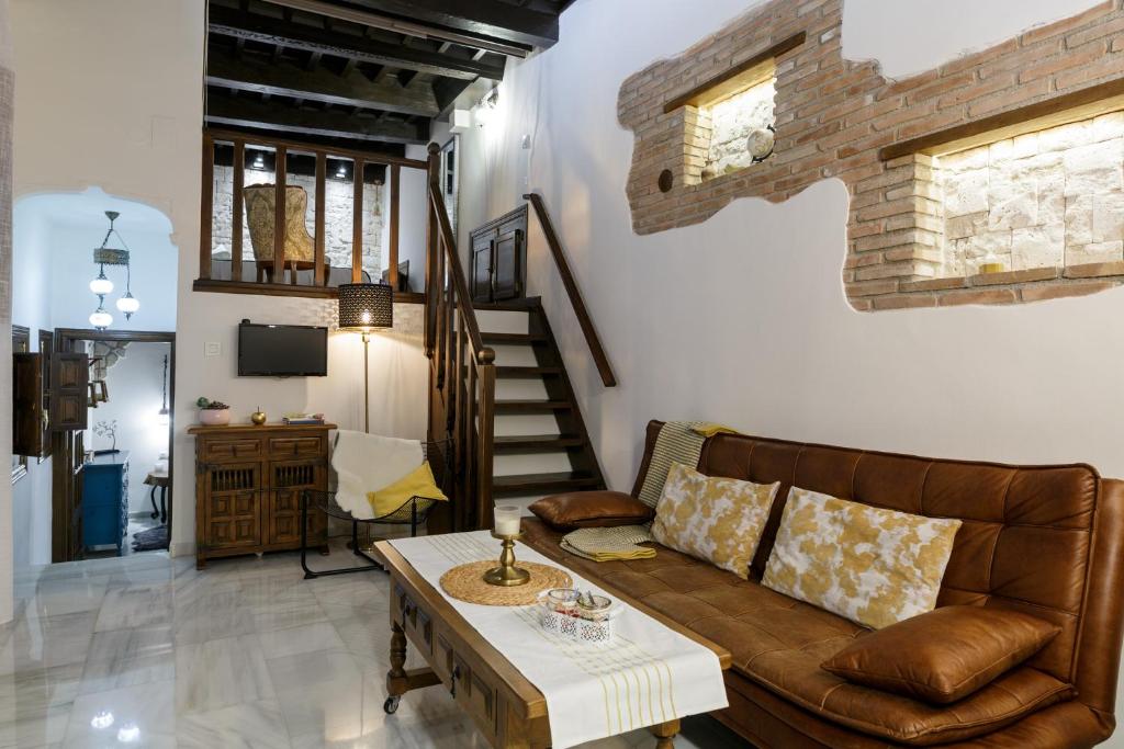 ein Wohnzimmer mit einem Sofa und einem Tisch in der Unterkunft Meraki Suites Dauro in Granada