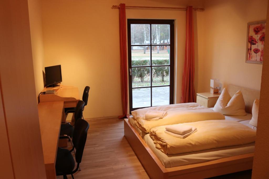 a bedroom with a bed and a window at Störitzland Betriebsgesellschaft mbH in Grünheide
