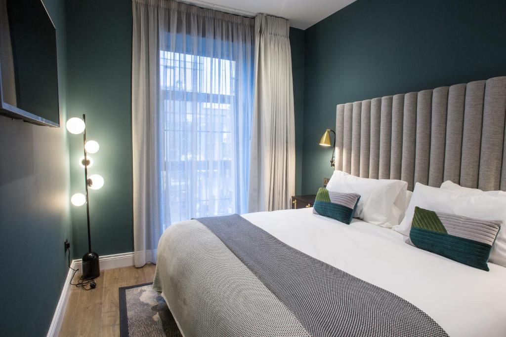 リムリックにあるThe Bedford Townhouseのベッドルーム1室(大きなベッド1台、大きな窓付)