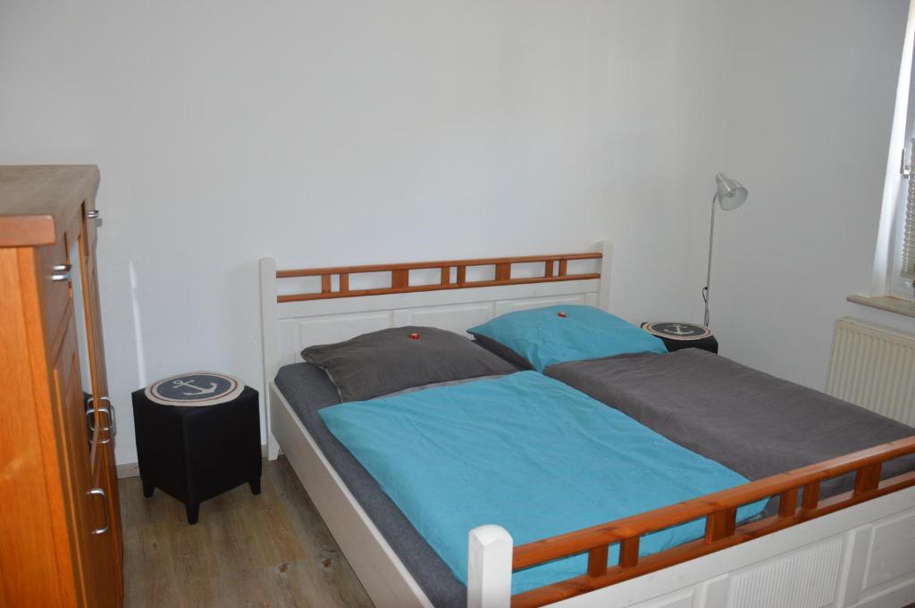 ヴァンガーオーゲにあるFeWo "Unser Boot"のベッドルーム1室(青いシーツと枕のベッド1台付)