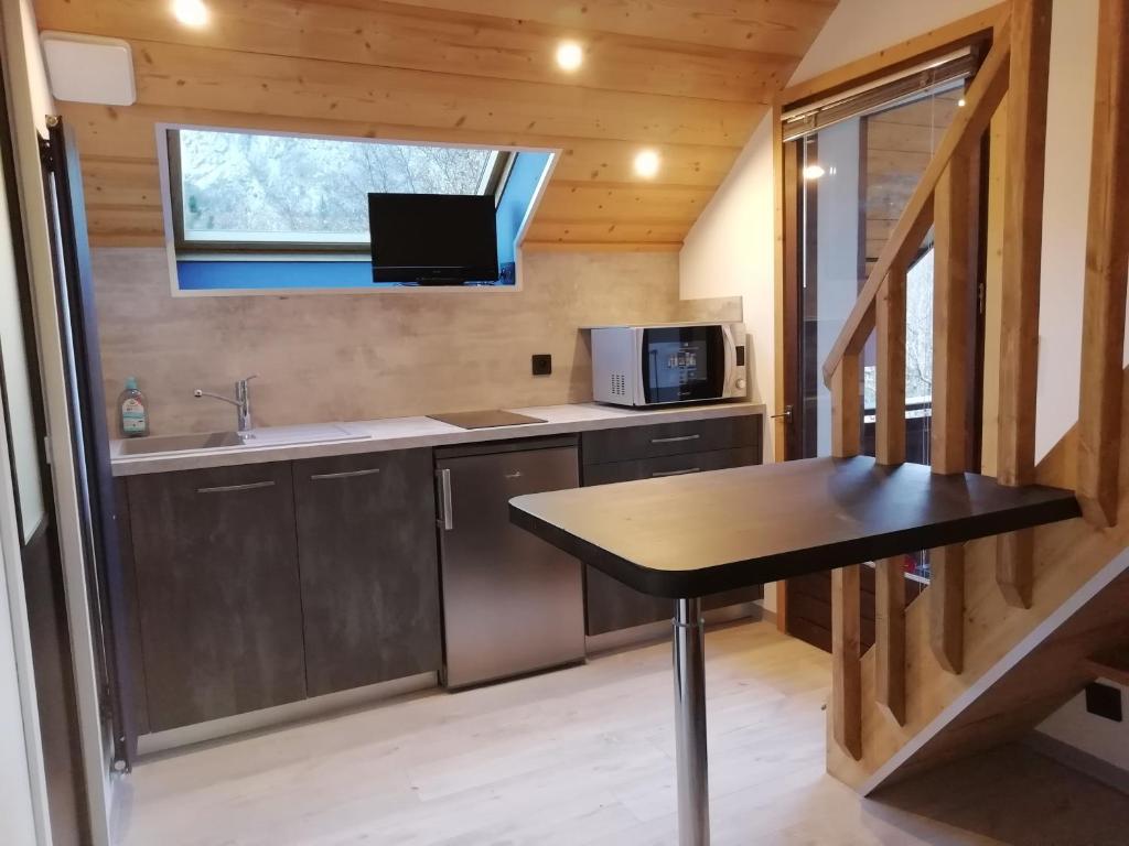 a small kitchen with a table in a tiny house at Studio en Duplex Renové in Thônes