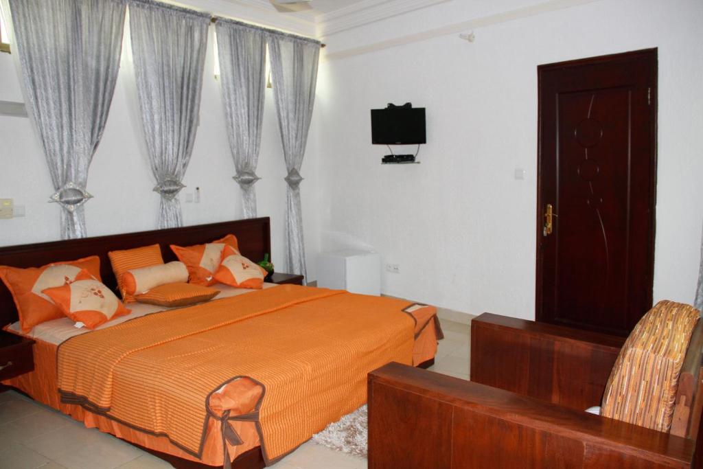 科托努的住宿－Amazing Grace Residence，一间卧室配有一张床和一台电视