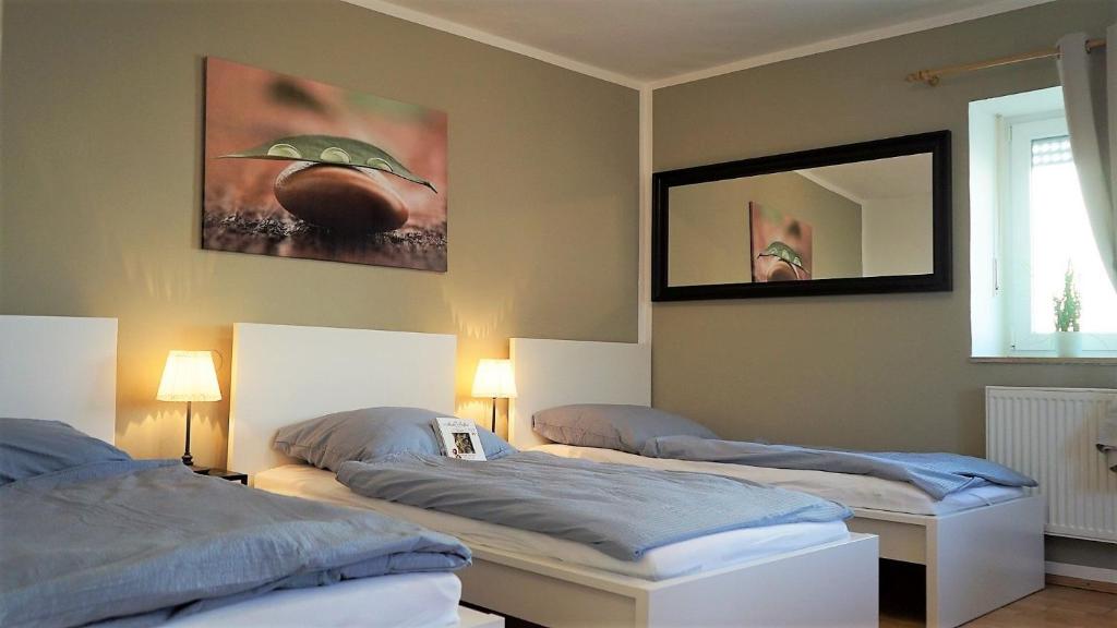 a bedroom with two beds and a mirror on the wall at Work & longstay apartment Ingolstadt in Adelschlag