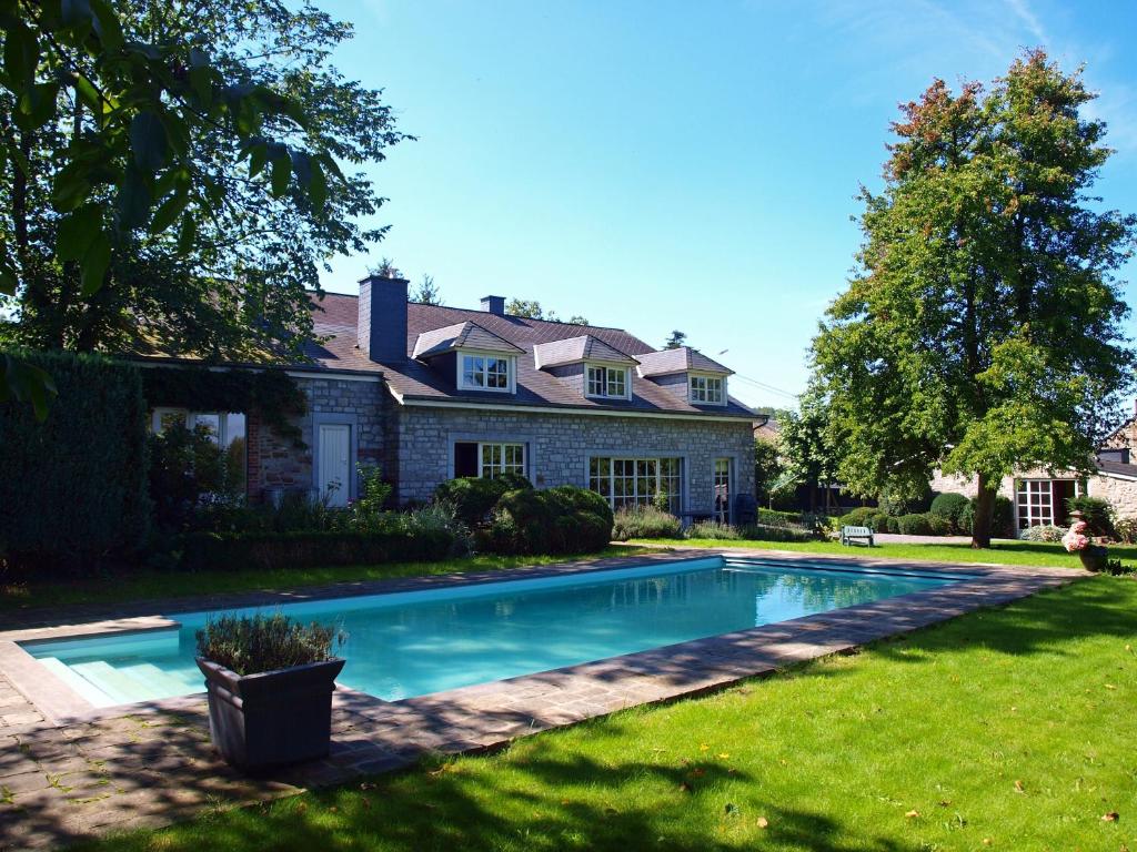 une maison avec une piscine dans la cour dans l'établissement B&B La Buissonniere, à Xhoris