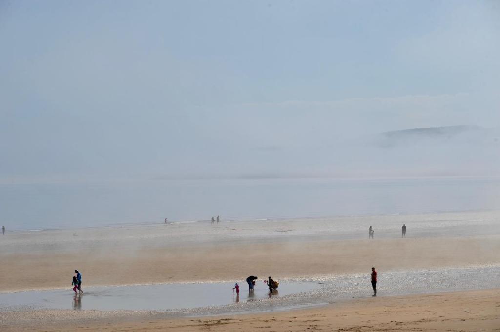 a group of people standing on a beach at Sea View Guest House in Benllech