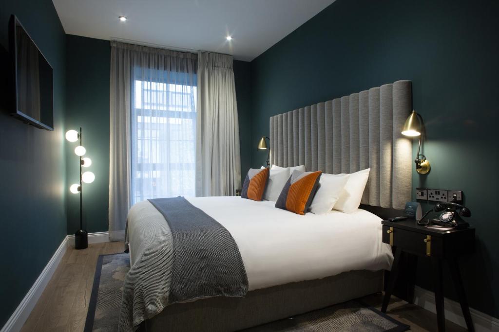 um quarto com uma cama grande e uma janela grande em The Bedford Townhouse em Limerick