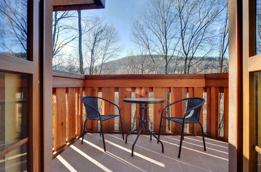 a patio with two chairs and a table on a balcony at Apartament Czekoladowy in Karpacz