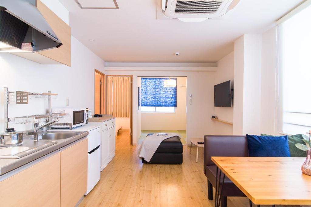 uma cozinha com uma mesa e uma sala de jantar em TEN APARTMENT HOTEL em Fukuoka