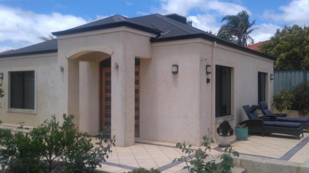 a small white building with a couch in front of it at Lake Estate Stay in Perth