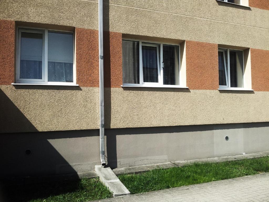 ein Gebäude mit zwei Fenstern und einer Stange in der Unterkunft Park Apartment in Ventspils