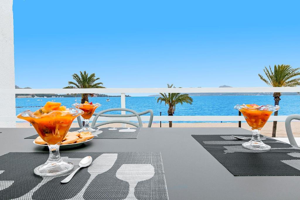 uma mesa com bebidas com o oceano ao fundo em Apartment Sirella 2 em Pollença