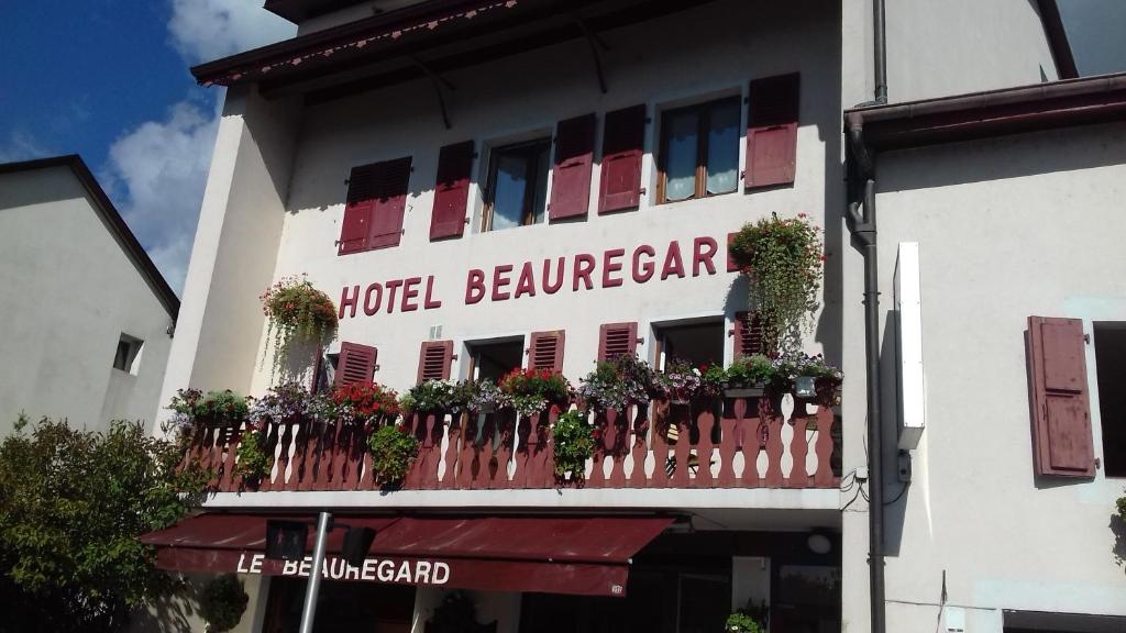a hotel building with a balcony with plants on it at Hotel Pension Le Beauregard in Divonne-les-Bains