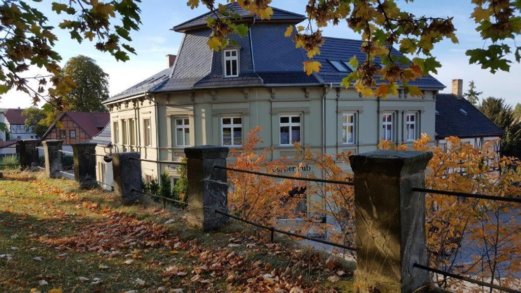 ein altes Haus mit einem Zaun davor in der Unterkunft Stiftsblick in Gernrode - Harz
