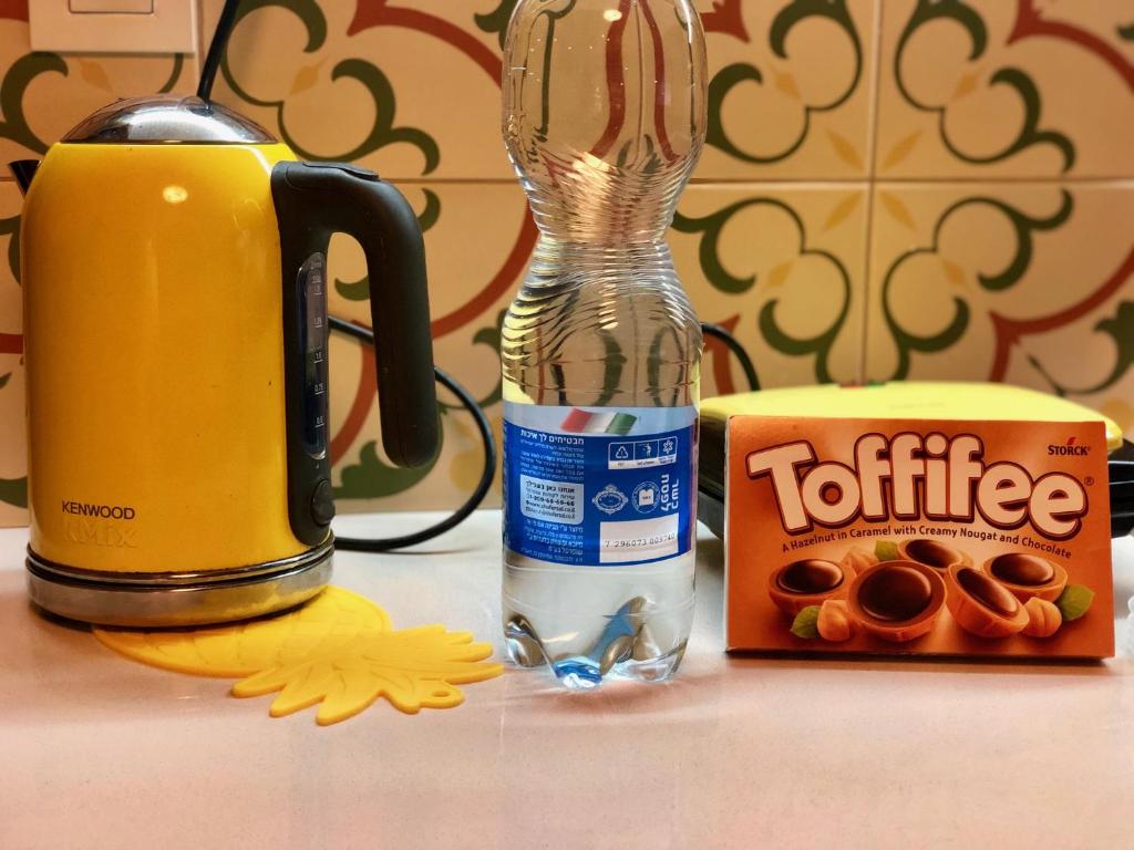 a bottle of coffee next to a box of donuts at Sweet Home, Only 7 Min to the beach - By SEAELO EILAT in Eilat