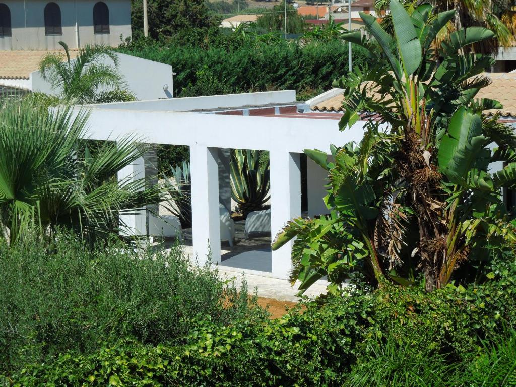 une maison blanche entourée d'arbres et de plantes dans l'établissement Villa Aloe, à Menfi