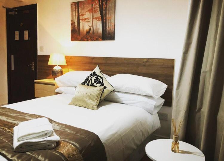 考文垂的住宿－Bede Apartments，卧室配有一张带白色床单和枕头的大床。