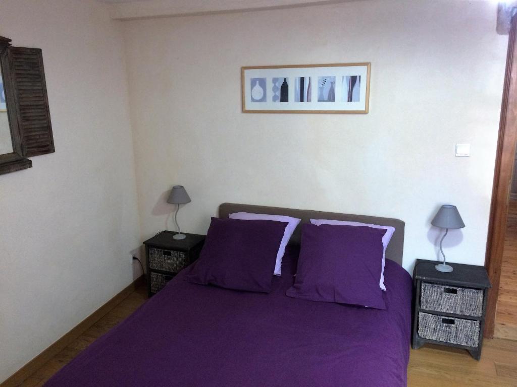 ベーブレンハイムにあるGite de la Vieille Forgeのベッドルーム(紫のシーツと枕付)